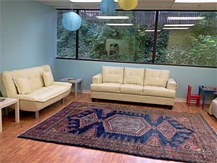 The Natural Pediatrics waiting room, with couches, paper lanterns and a toy corner by the window.
