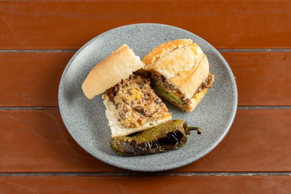 Steak — Griddled sliced beef and melted cheese in a long roll.